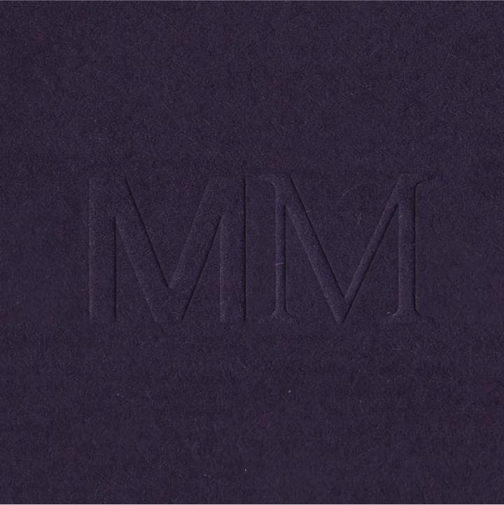Branding Design for Mendi Moke, the MM monogram embossed on dark purple paper